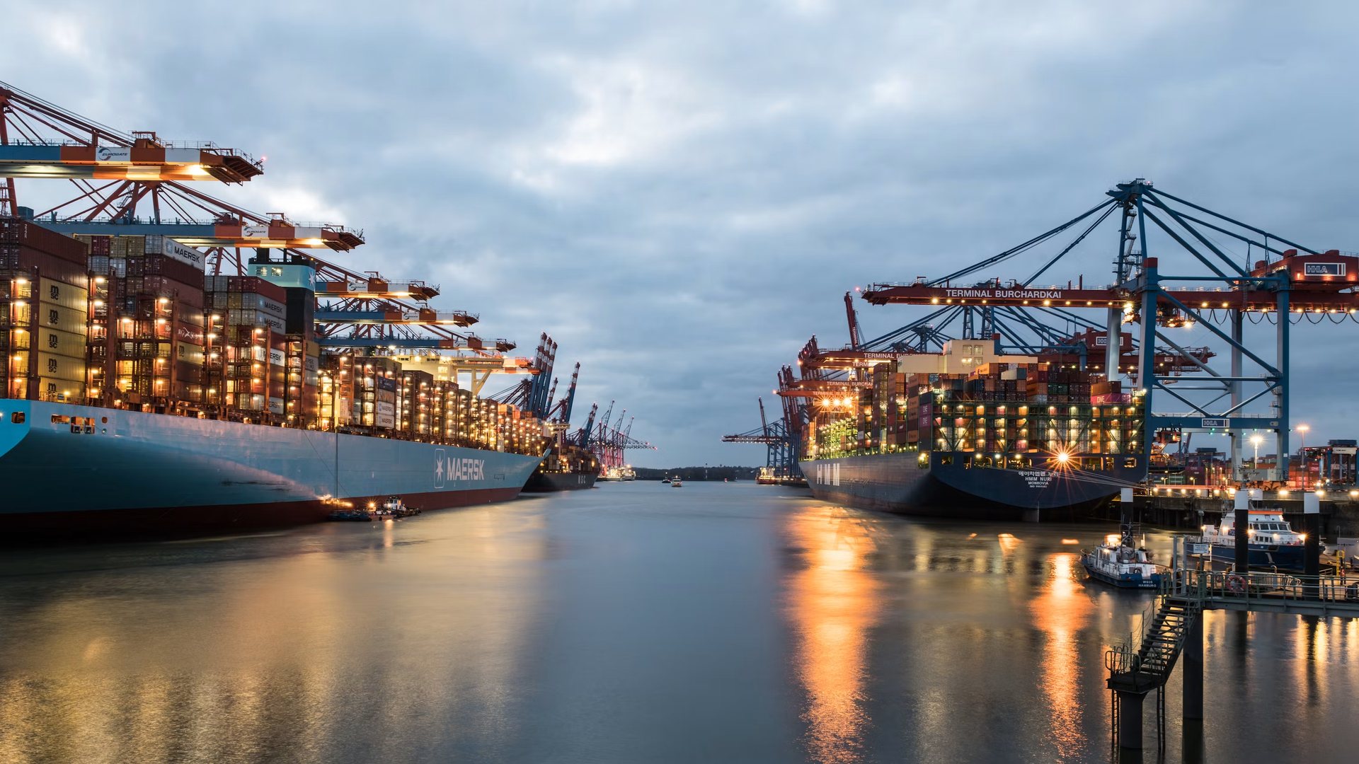 Container port with cranes and ships at dusk